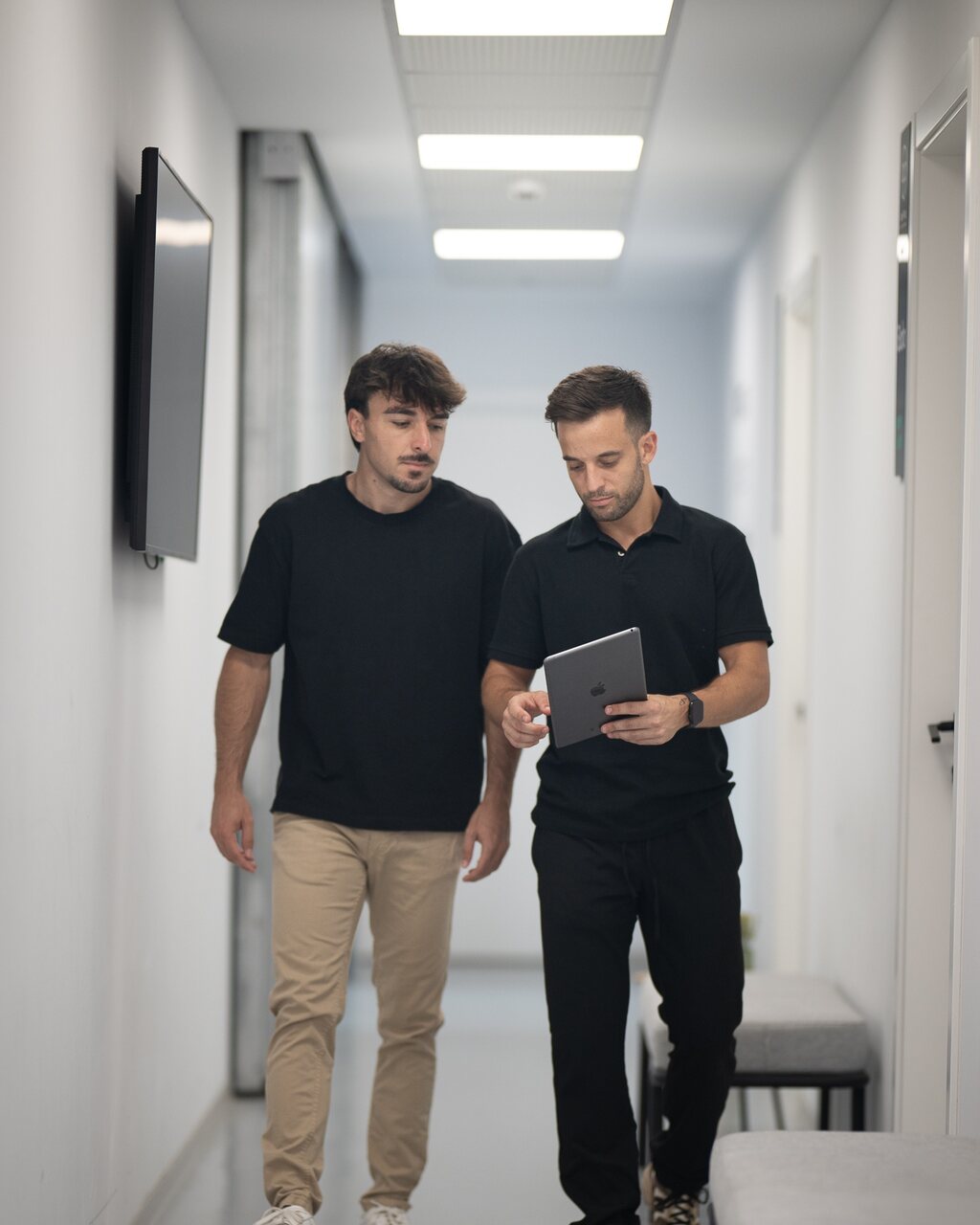 Abel Pérez y un cliente revisan la evolución del plan en una tablet mientras caminan por la consulta de AP Nutrición Inteligente en Alzira